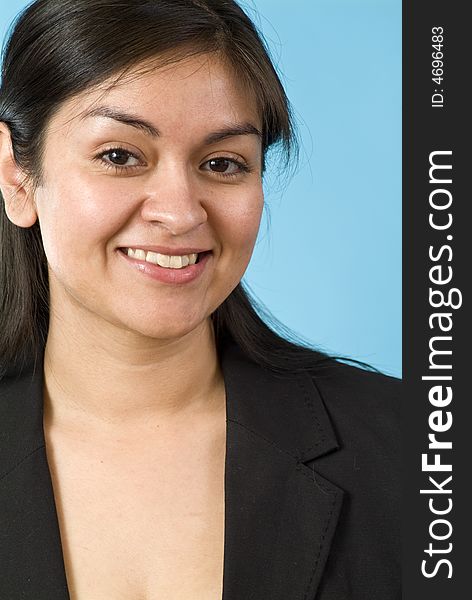 Young Hispanic girl smiling for the camera in front of a blue screen. Young Hispanic girl smiling for the camera in front of a blue screen