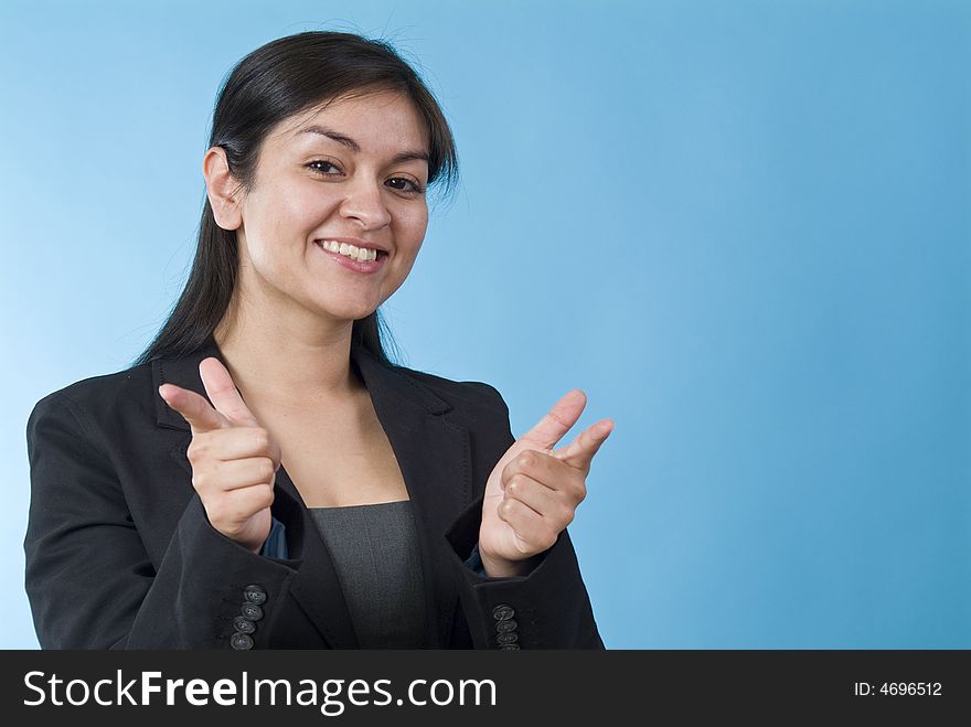 A pretty young woman smiling and making a affirming, pointing gesture at the camera. A pretty young woman smiling and making a affirming, pointing gesture at the camera.