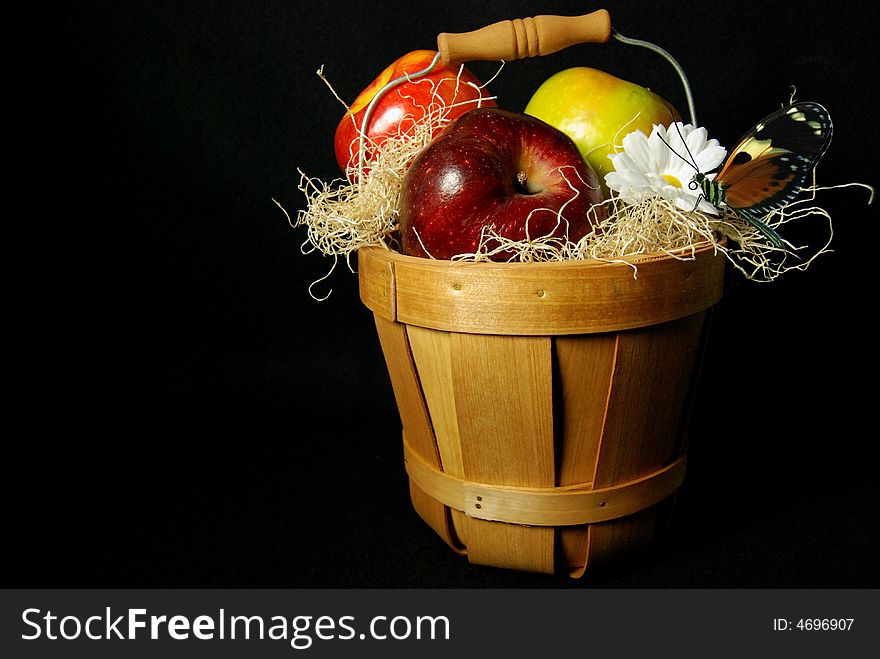 Ripe and juicy apples a wooden basket with a daisy and a butterfly. Ripe and juicy apples a wooden basket with a daisy and a butterfly.