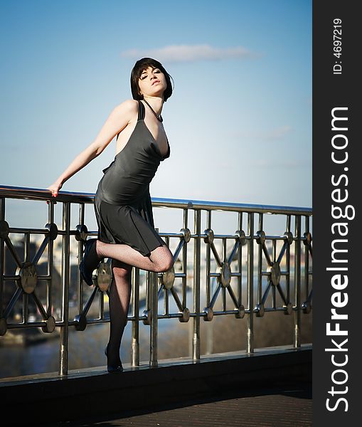 Young girl posing above the city on the roof of the building. Young girl posing above the city on the roof of the building