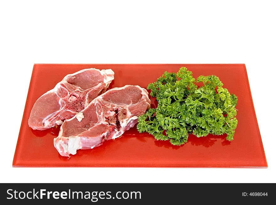 Lamb chops on red plate, white background, studio shot