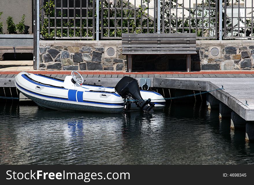 An inflatable boat tied up next to a pier. An inflatable boat tied up next to a pier