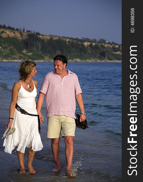 A couple having a romantic stroll through the waves Kefalonia Greece