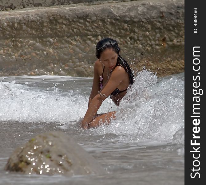 The sunbathed young white woman lays in a surf during a storm on the sea. The sunbathed young white woman lays in a surf during a storm on the sea