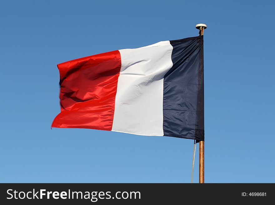 The French tricolour flapping in the wind on a flagpole. The French tricolour flapping in the wind on a flagpole.