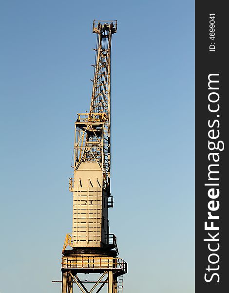 A dockside crane against a blue sky