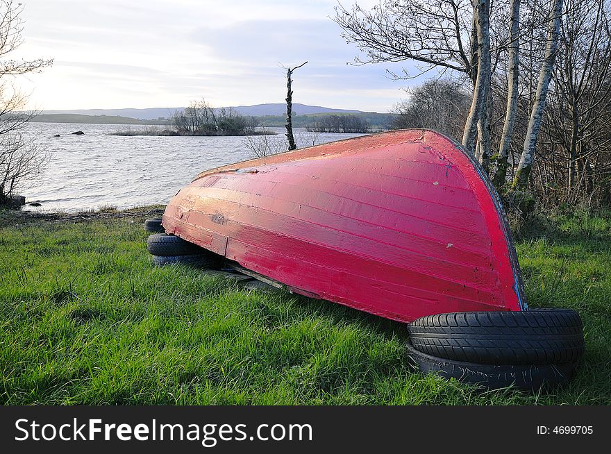 Red boat on the shores of a lake. Red boat on the shores of a lake