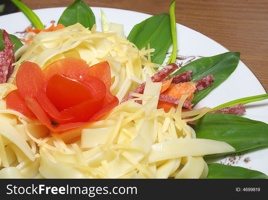 Pasta with cheese, salami, tomatoes and herbs on a white plate (Shallow deep of field)