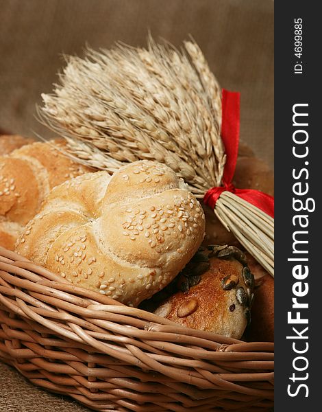 A closeup of a different bread with wheat grains and stalks placed next to it. A closeup of a different bread with wheat grains and stalks placed next to it.