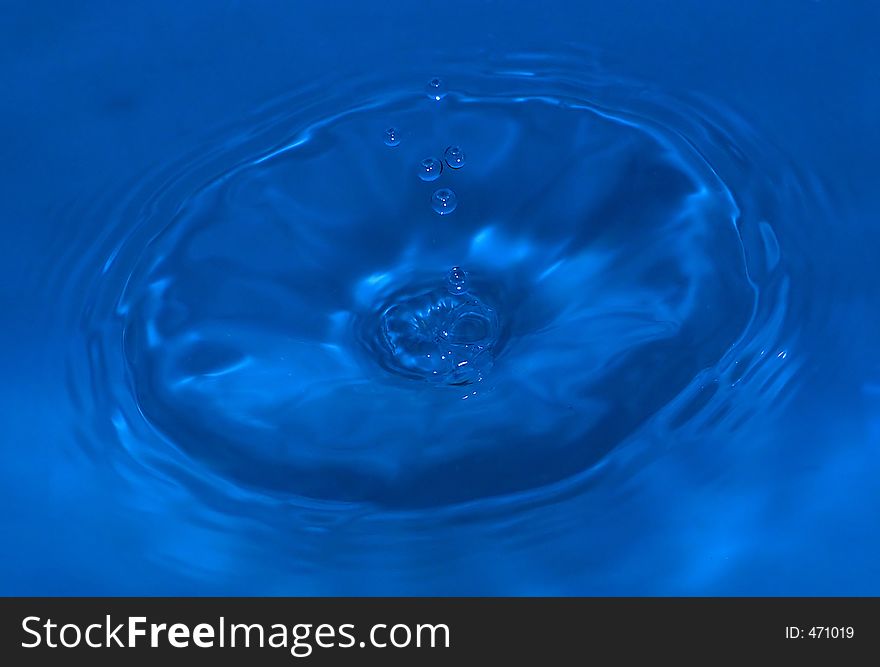 Water drop captured on impact with the still water surface