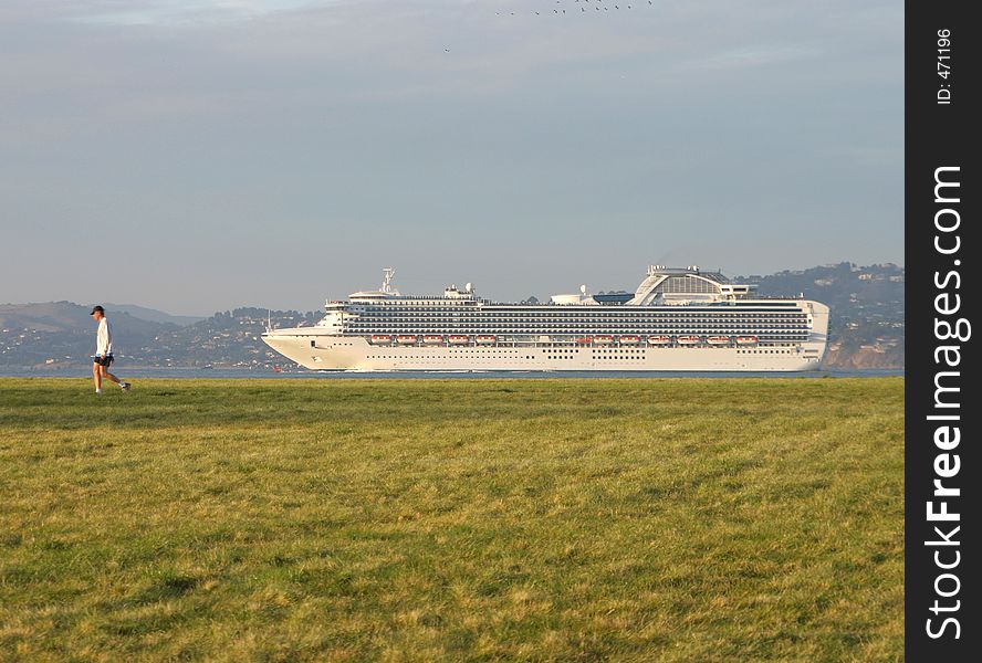 A man is seemingly followed by a cruise ship as he takes a walk on San Francisco's Crissy Field. A man is seemingly followed by a cruise ship as he takes a walk on San Francisco's Crissy Field.