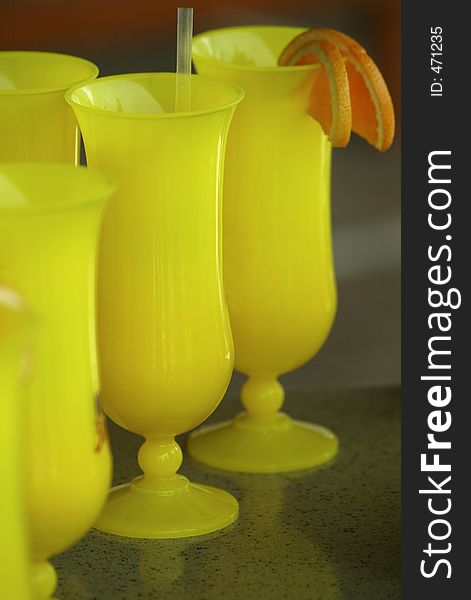 Yellow drink glasses garnished with orange slices. Yellow drink glasses garnished with orange slices