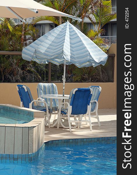 Blue chairs and sunshade by the pool. Blue chairs and sunshade by the pool