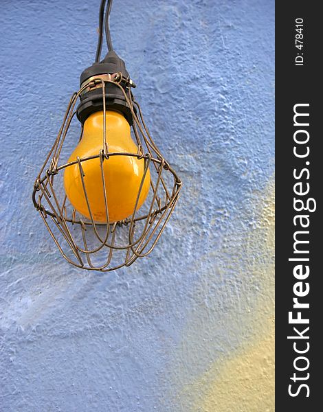 Yellow light bulb against a blue background - copy space. Yellow light bulb against a blue background - copy space