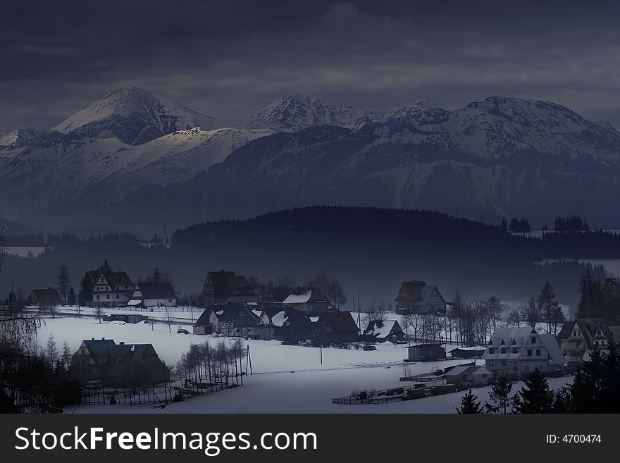 Houses at the foot of mountains in a cold day