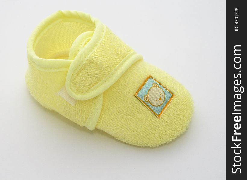 One babies shoe in a yellow towelling fabric