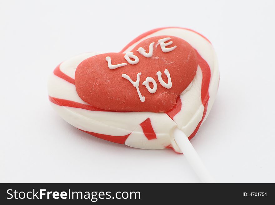 Candy lolly with love you written on a red heart. Candy lolly with love you written on a red heart