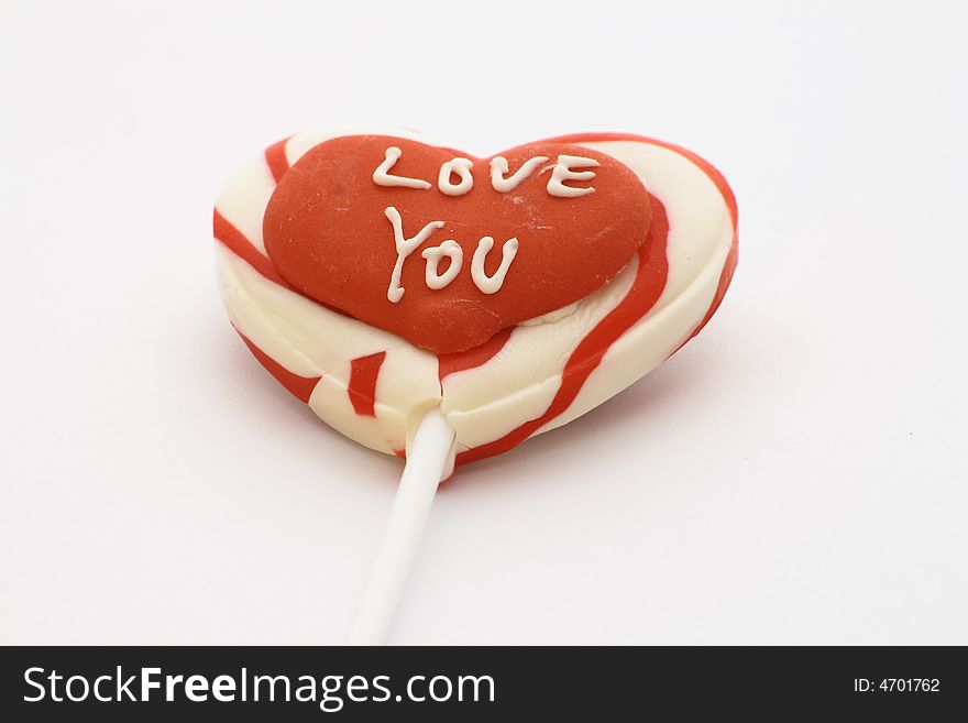 Candy lolly with love you written on a red heart. Candy lolly with love you written on a red heart