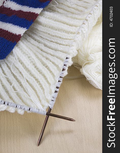 Knitted fabric with needles on wooden surface. Knitted fabric with needles on wooden surface.