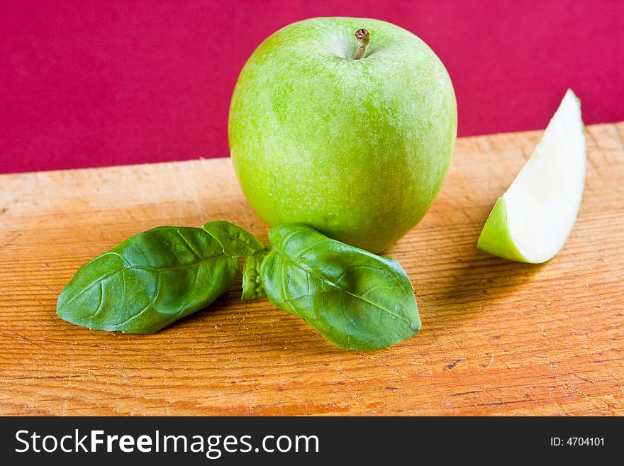 A green apple with a freshly cut apple slice. A green apple with a freshly cut apple slice