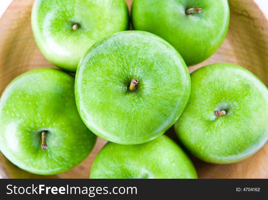Green apples in a wooden bowl taken from above. Green apples in a wooden bowl taken from above