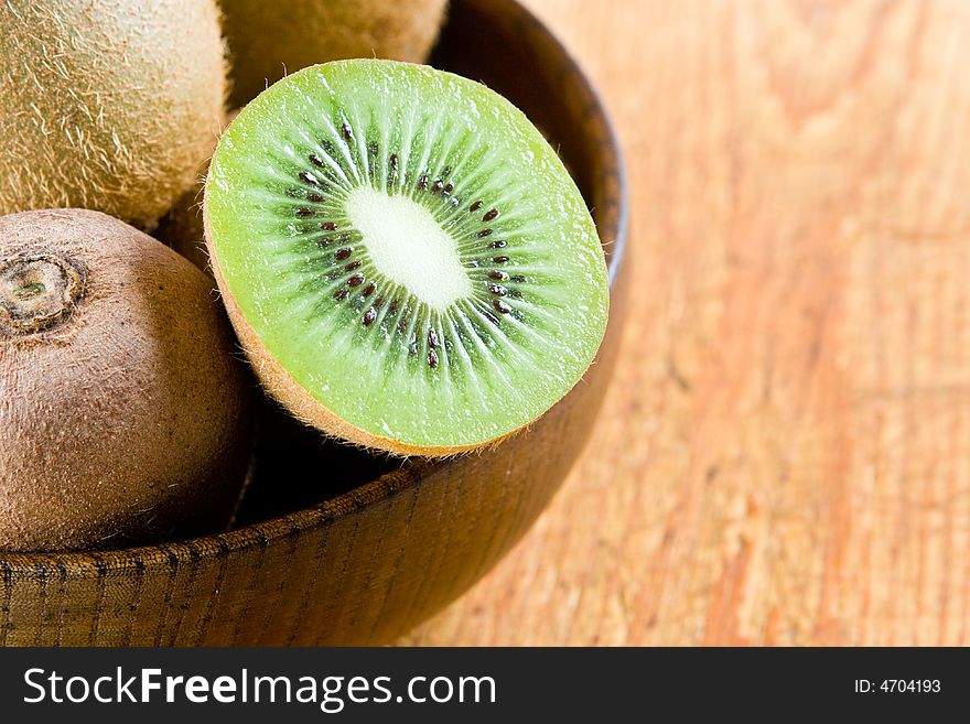 Half a kiwi in a wooden bowl