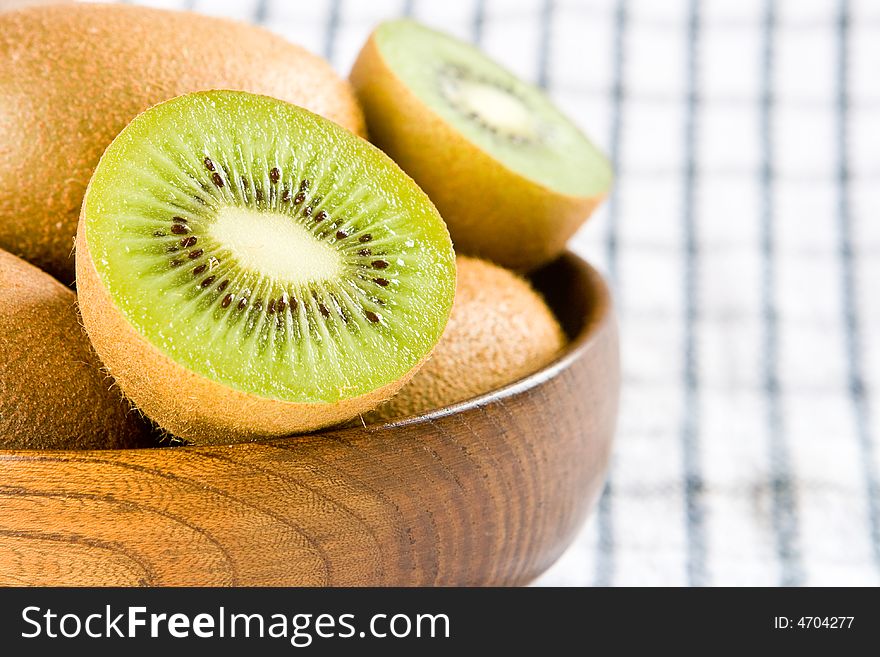 Two kiwi halves in a wooden bowl