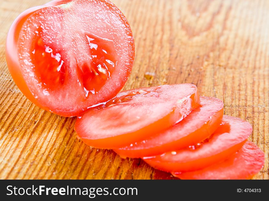 A sliced tomato on a wooden board