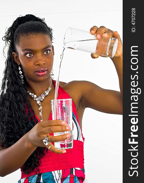 Sweet african girl pouring water into a glass. Sweet african girl pouring water into a glass