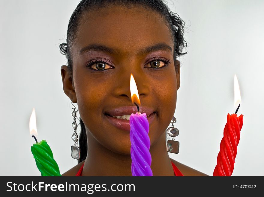 Beautiful young woman with three colored candles