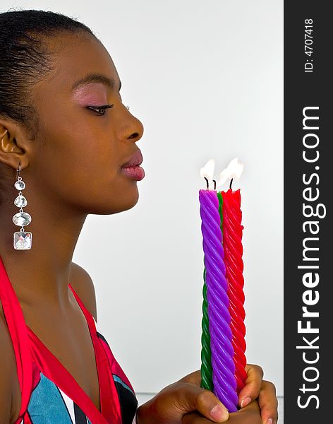 Beautiful young woman with three colored candles