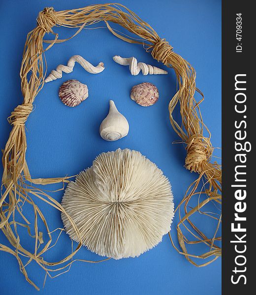 Seashells and a solitary mushroom coral arranged like a face of a woman with big lips and straw hairs, on blue background. Seashells and a solitary mushroom coral arranged like a face of a woman with big lips and straw hairs, on blue background