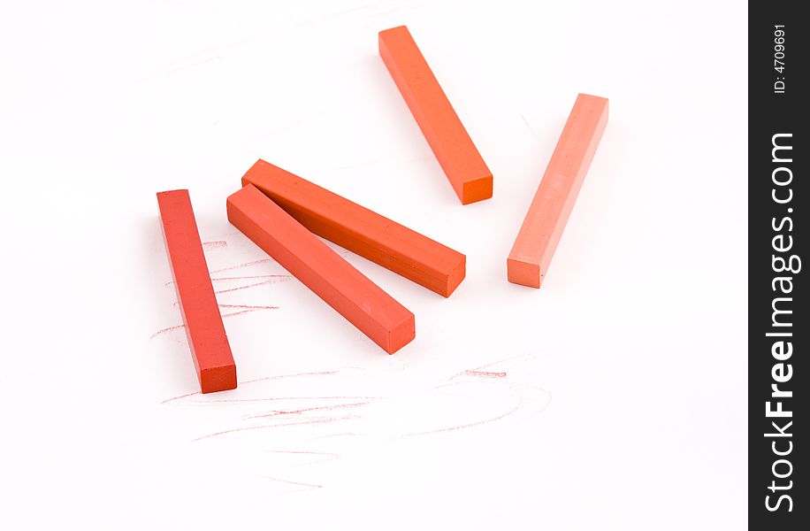 Red and orange square pastel crayons on white background. Red and orange square pastel crayons on white background