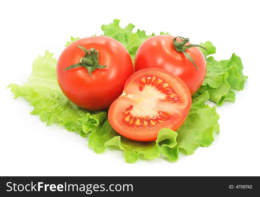 Fresh tomatoes with cut on sheet of salad isolated on the white background