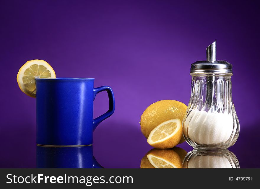A blue cup of tea with lemons and sugar