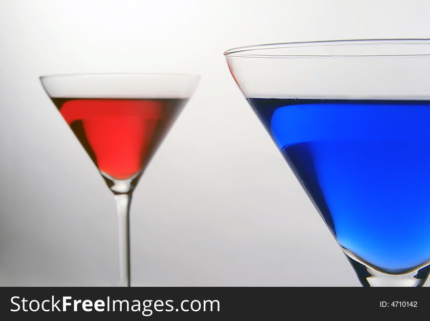 Macro shot of a blue cocktail with red behind