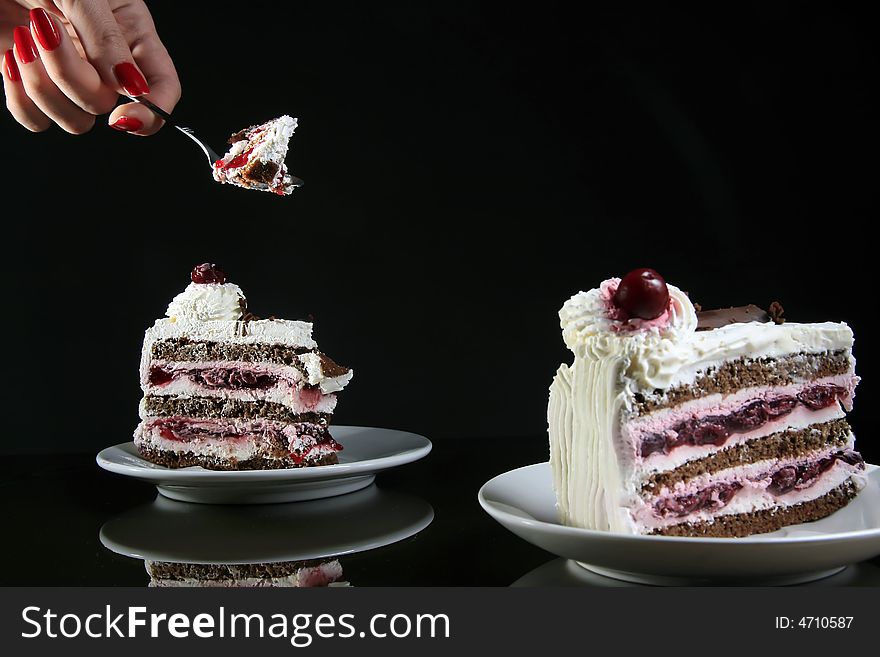 Two pieces of cake with female hand and spoon. Two pieces of cake with female hand and spoon