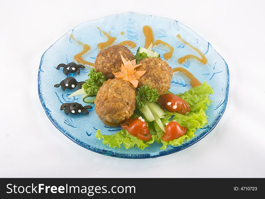 Meat balls for kids on a blue transparent plate with little crabs made out of black olives and red tomatoes.