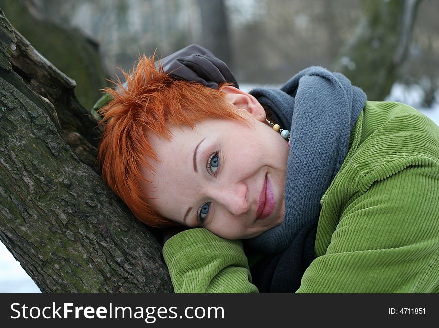 A beautiful blue eyed young woman near tree