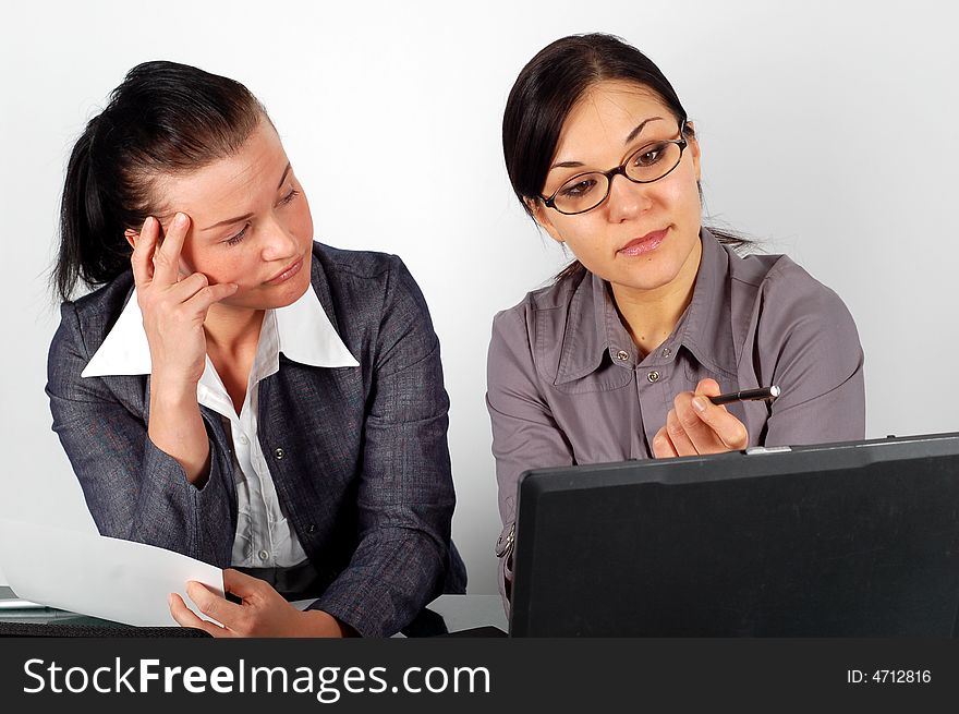 Two attractive brunette women working in office. Two attractive brunette women working in office