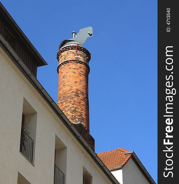 Brick chimney on a roof in the old historical Bavarian City Wasserburg .Blue Sky as backround . Brick chimney on a roof in the old historical Bavarian City Wasserburg .Blue Sky as backround .