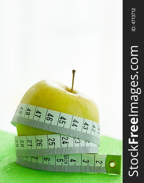 Green apple and tape measure