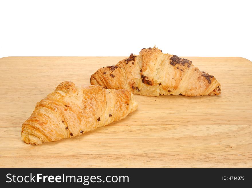 Two croissants on a wooden board