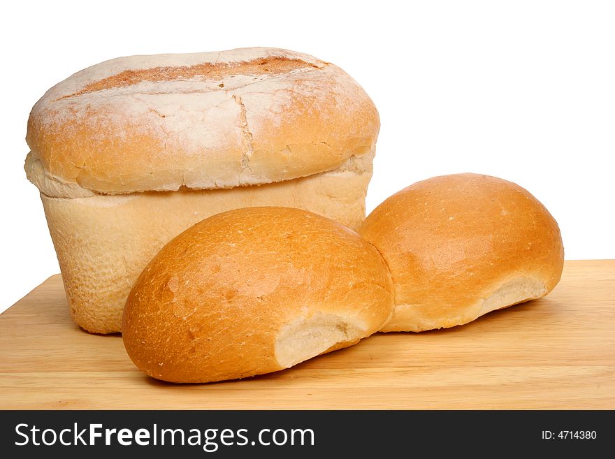 Bread loaf and rolls on wooden board
