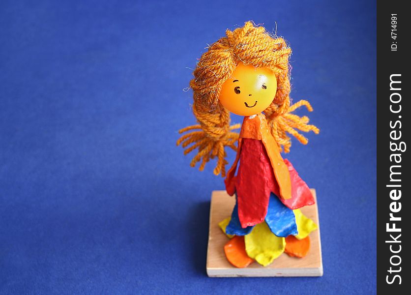 Doll with blond hair on blue background. Doll with blond hair on blue background