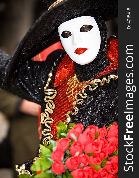 Stylish venetian women in costume with a bunch of roses