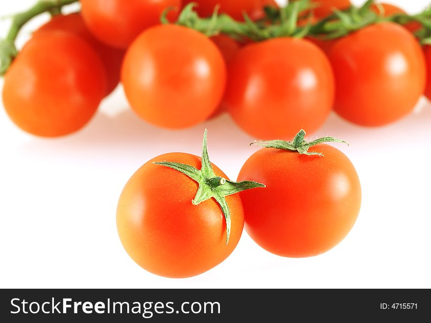 Lots of fresh juicy tomatos with two in front over white background