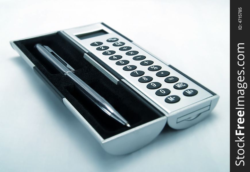 An elegant calculator and a silvery pen. An elegant calculator and a silvery pen