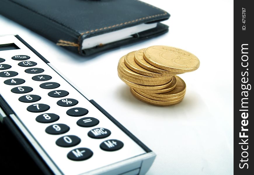 An elegant calculator and golden coins. An elegant calculator and golden coins