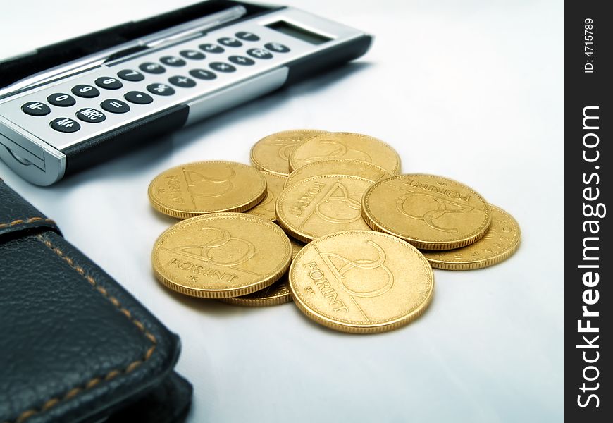 An elegant calculator and golden coins. An elegant calculator and golden coins